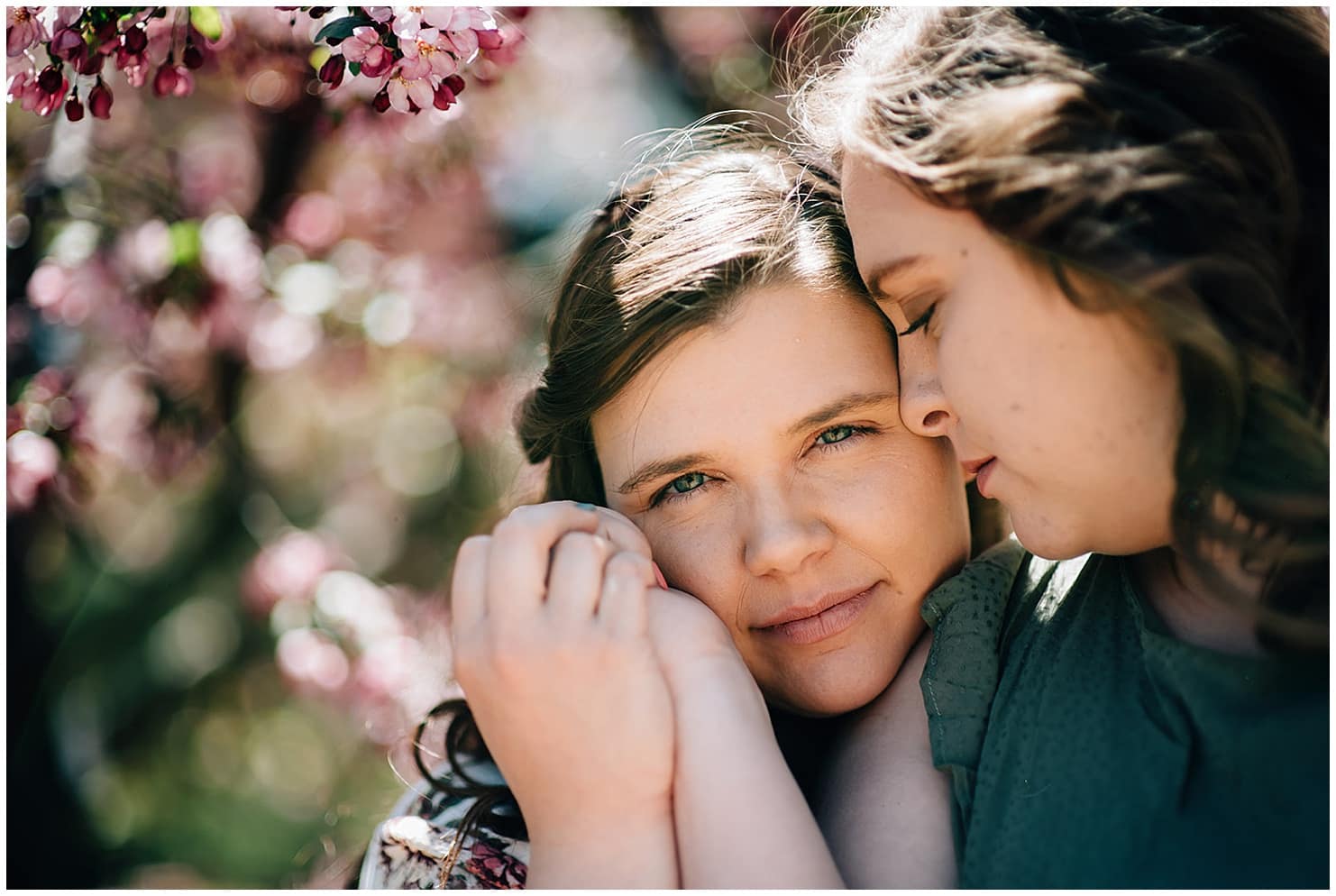 two girls snuggling new blooming trees