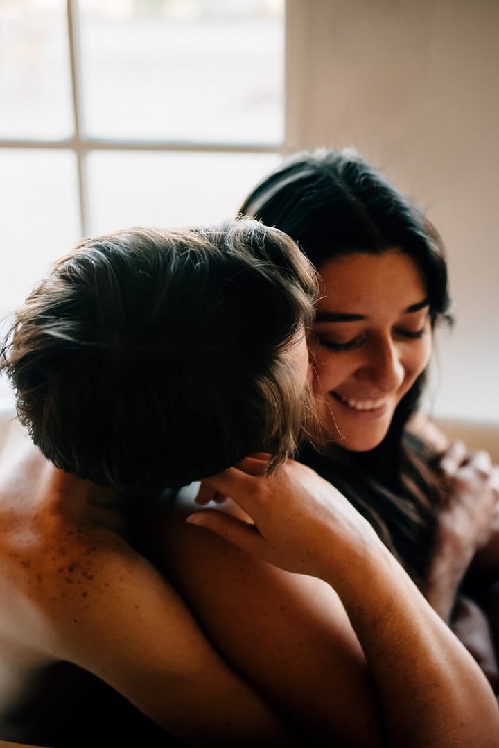 couple in bathtub where man is nuzzling woman's neck